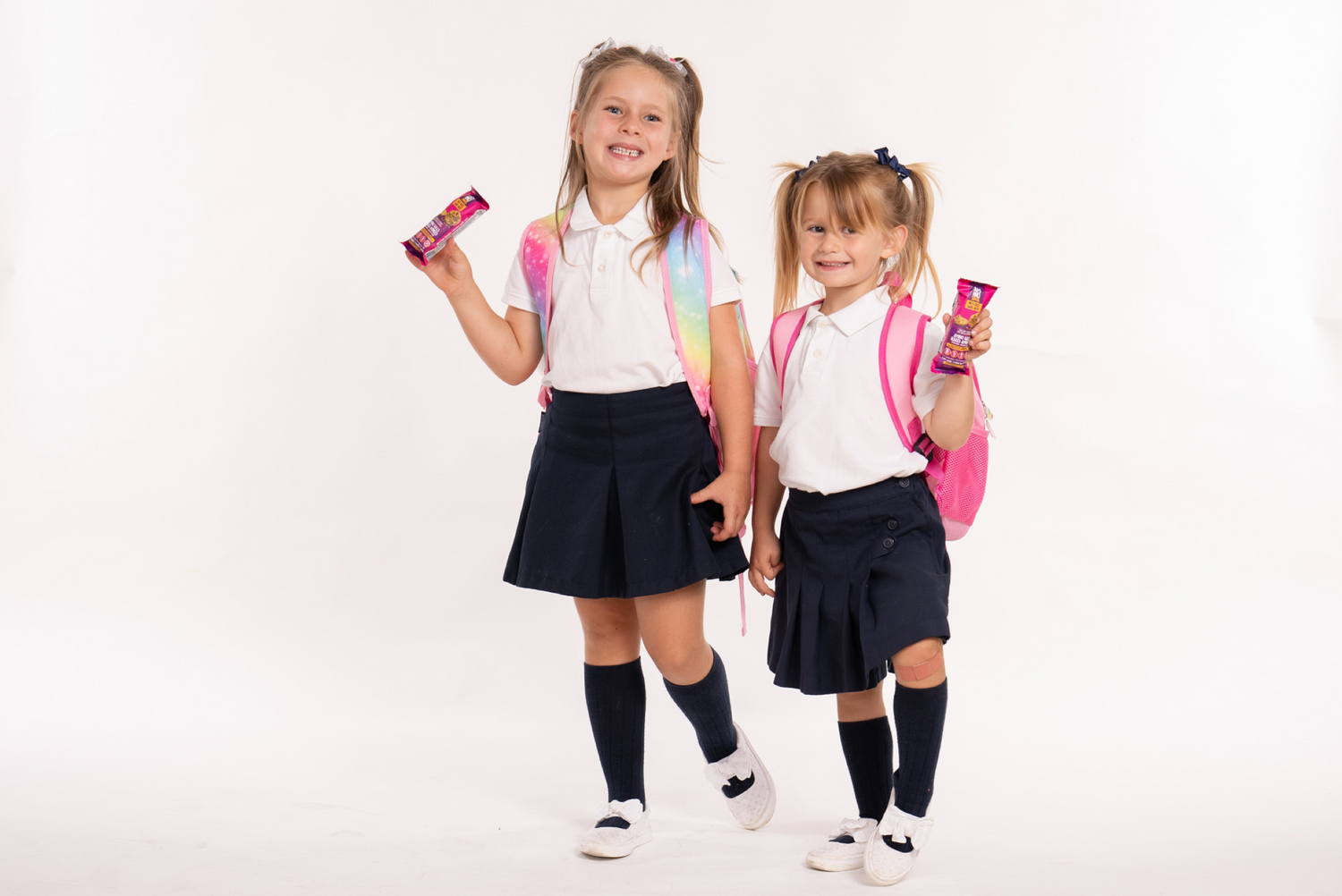 Photo of school children in school uniforms holding amino balls snacks