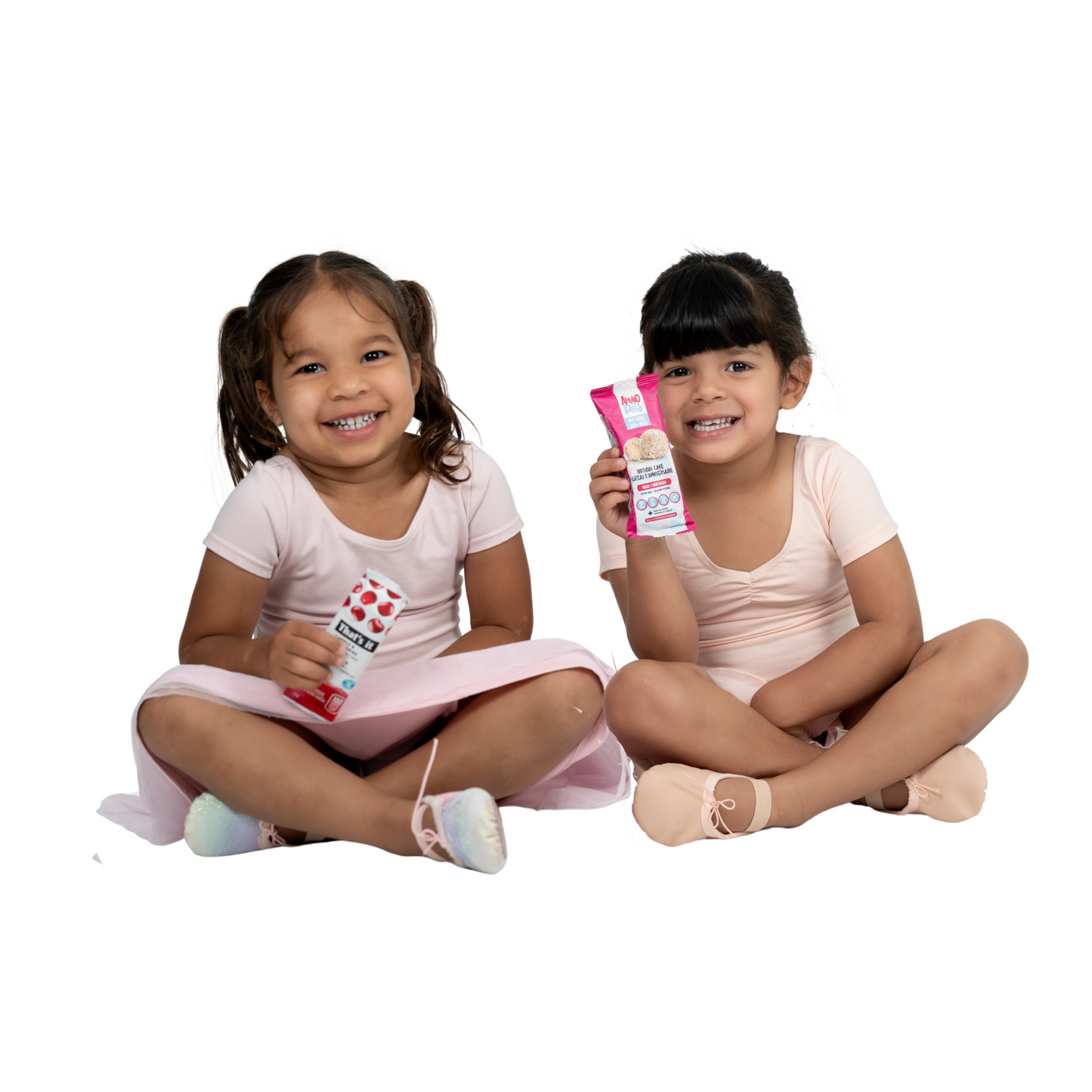 Two young girls in ballet outfits with snacks