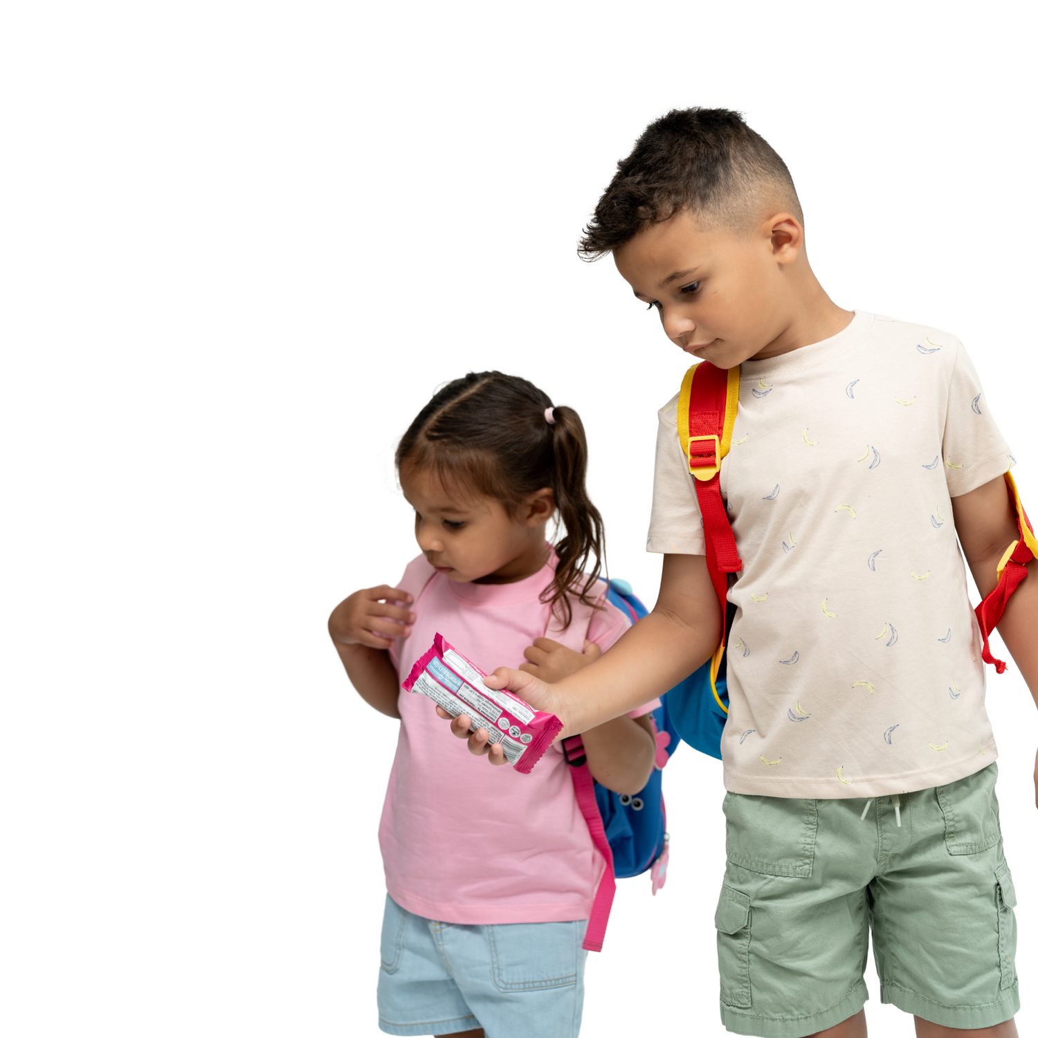 Photo of young boy and girl with backpacks sharing snacks
